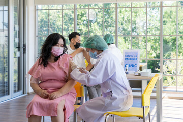 Doctor injecting covid-19 vaccine into a fat woman in the hospital to prevent of coronavirus