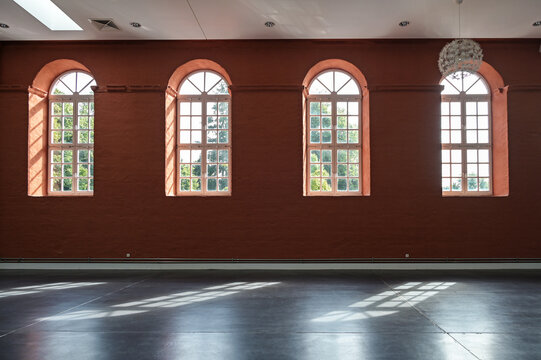 Putbus, Germany, August 22, 2021: red wall with arched windows in the empty hall of the Marstall in Putbus, Rugen, architecture and interior concept, copy space, selected focus
