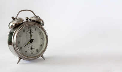 Vintage alarm clock on white background. Selective focus. Copy space.