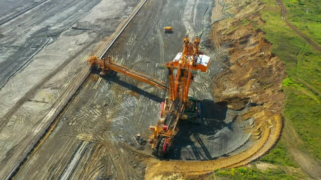 Bucket wheel excavator at work in coal mine. Mining industry from above. Open pit in Central Europe. Heavy industry before Green deal.