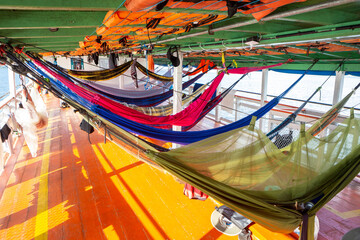 Colorful hammocks on Amazon Rainforest wooden boat in sunny summer day. Alter do Chão, Para,...