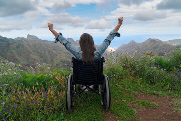 Disabled handicapped woman in wheelchair on mountain hill enjoying view