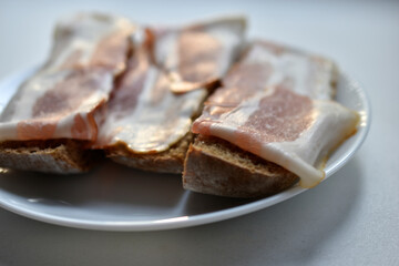 Fresh juicy bacon on a piece of rye bread