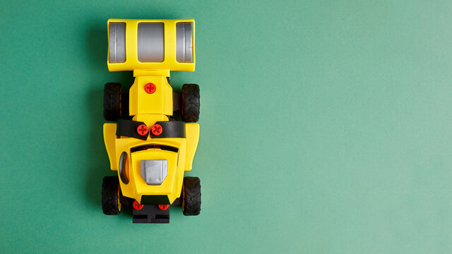 Children's plastic toy car on a green background. Photo for a toy store with a place to copy