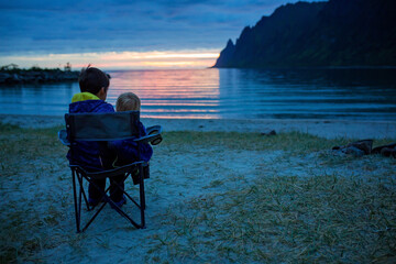 Children, enjoying sunset on Ersfjord Beach on Senja island, beautiful landscape view over the mountains