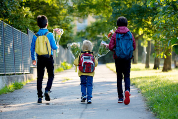 Happy children, going to school in the morning, first day, caring bouquet of flowers for the teacher