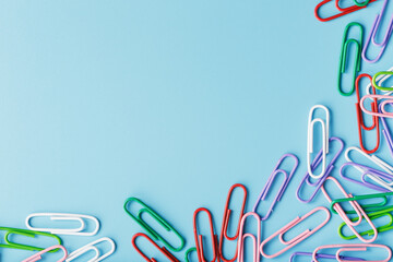 Multicolored paper clips on a blue background.