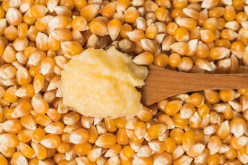 Aerial view of a spoon with cooked cornstarch on a pile of corn