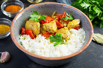 Spicy chicken curry with rice. Curry sauce with chicken and rice on dark background