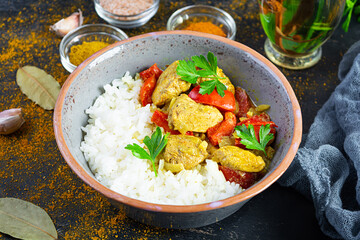 Spicy chicken curry with rice. Curry sauce with chicken and rice on dark background