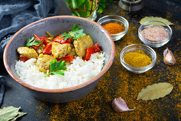Spicy chicken curry with rice. Curry sauce with chicken and rice on dark background