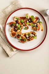 Gourmet salad with ripe figs, goat chevre cheese, fresh cucumber roll, beetroot and mustard leaves with tomato sauce. Summer salad without meat. Delicious and healthy food. Copy space. Top view