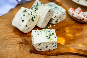 Slice of sheep cheese on a wooden background made from homemade fresh milk.