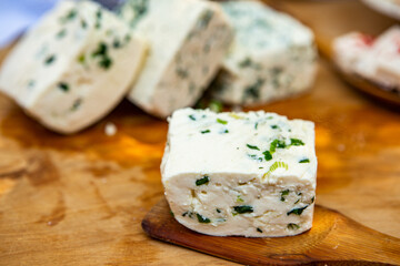 Slice of sheep cheese on a wooden background made from homemade fresh milk.