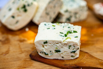 Slice of sheep cheese on a wooden background made from homemade fresh milk.