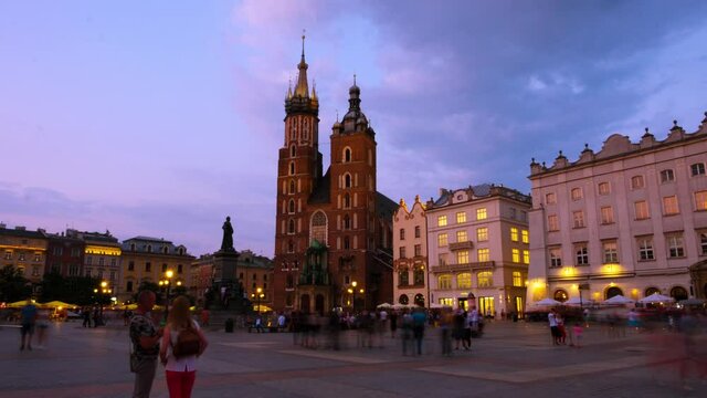 Krakow, Poland. View of the central main market square in Krakow, Poland with Bazylika Mariacka. Time-lapse with the sunset sky