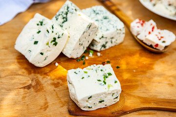 Slice of sheep cheese on a wooden background made from homemade fresh milk.