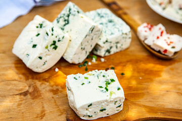 Slice of sheep cheese on a wooden background made from homemade fresh milk.