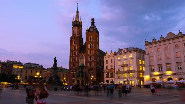 Krakow, Poland. View of the central main market square in Krakow, Poland with Bazylika Mariacka. Time-lapse with the sunset sky, zoom in