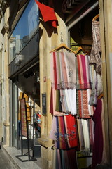 Tücher und Schals aus bunten Stoffen im Sommer bei Sonnenschein am Eingang eines Geschäfts in der...
