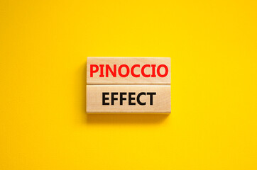 Pinoccio effect symbol. Concept words Pinoccio effect on wooden blocks on a beautiful yellow background. Business and Pinoccio effect concept, copy space.