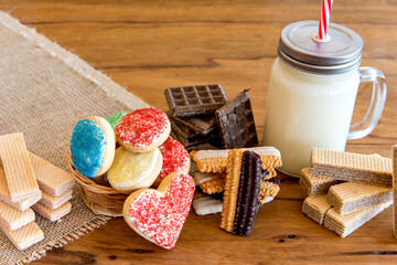 dipping biscuits in milk, Various types of cookies and biscuits, stuffed and homemade with glass of milk.