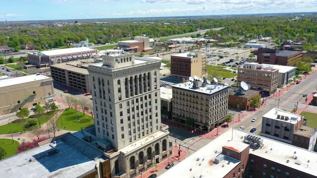 Good drone aerial of downtown Saginaw, Michigan with old buildings and empty lots, suggesting economic downturn.