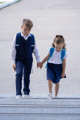 The older brother takes his younger sister to school