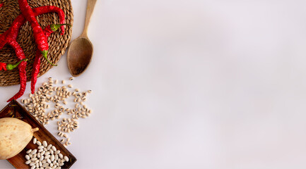 Red peppers on a wicker surface, wooden ladle, dried pumpkin and various types of beans. Mediterranean food. Top view. Flat lay. Copy space.