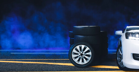 Wheel and tire pile on the asphalt road and blue smoke with black background at night