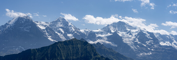 Panorama sur une chaine de hautes montagnes aux sommets enneigés