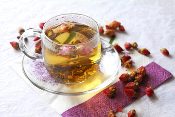 Glass transparent cup of green tea with rosebuds