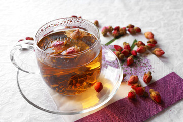 Glass transparent cup of tea with rosebuds