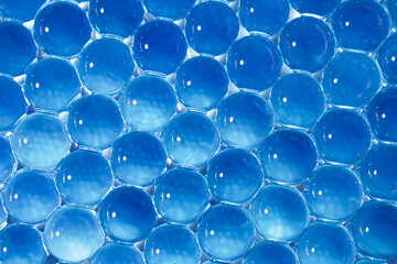 Blue gel balls. Macro of hydrogel refreshing background. Abstract wallpaper of bright 3d round pattern. Copy space