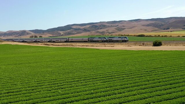 Aerial Of Amtrak Passenger Train Traveling Through Generic California Farm Country Near Martinez, California.