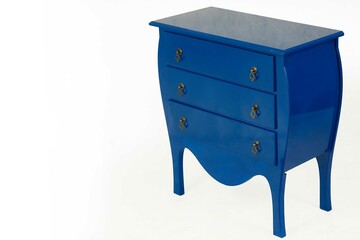 Criado mudo azul com três gavetas em fundo branco.