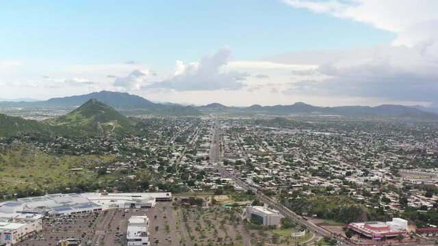 Aerial panoramic view of Hermosillo, Sonora. Drone flying sideways over Cerro de la Campana with a blue sky as background.