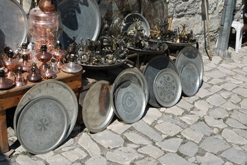 A display of traditional Turkish souvenirs of bronze and copper handcrafted cookware and souvenir on the pavement waiting for customers. Safranbolu UNESCO Turkey.