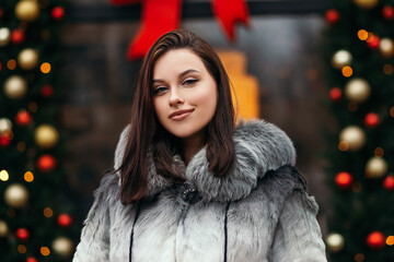 Fashion close up woman standing street european city new year decoration celebrating holiday 2022 dressed trendy eco friendly artificial fur coat winter snow nose piercing face big lips
