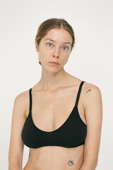 Fototapeta premium Beautiful girl without makeup with natural skin in lingerie on a white background