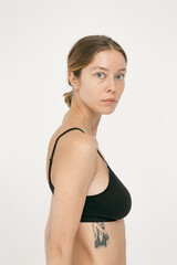 Fototapeta premium Beautiful girl without makeup with natural skin in lingerie on a white background