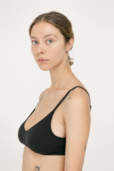 Fototapeta premium Beautiful girl without makeup with natural skin in lingerie on a white background
