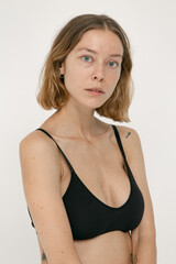 Fototapeta premium Beautiful girl without makeup with natural skin in lingerie on a white background