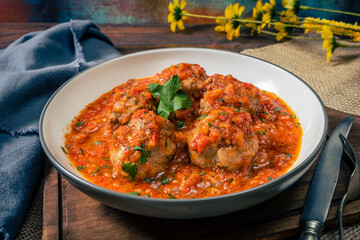 Meat balls or meatloaf with tomato sauce in a round dish. High view