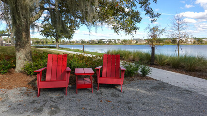 Two chairs sitting in a park by a lake in Laurete Park in Lake Nona, Orlando, FL on a beautiful...