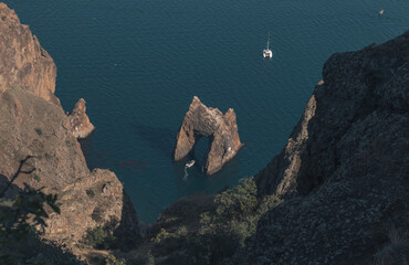Rocks on the seashore, white yachts sailing