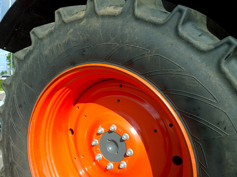 St. Petersburg, Russia - September 4, 2020: Mitas radial tyre and orange color disk of new modern tractor wheel. Higher load capacity. Agricultural machinery. Farmer business. Manufacturing equipment.