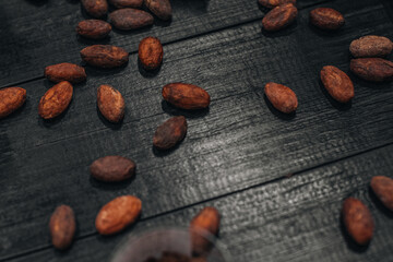 Dark cacao beans on a wooden rustic table background