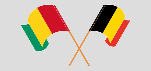 Crossed and waving flags of Guinea and Belgium