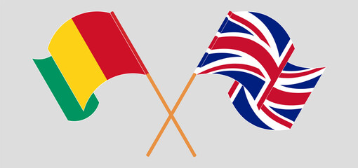 Crossed and waving flags of Guinea and the UK